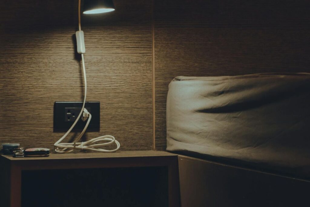 bedside shelf with wireless charging pad beside bed